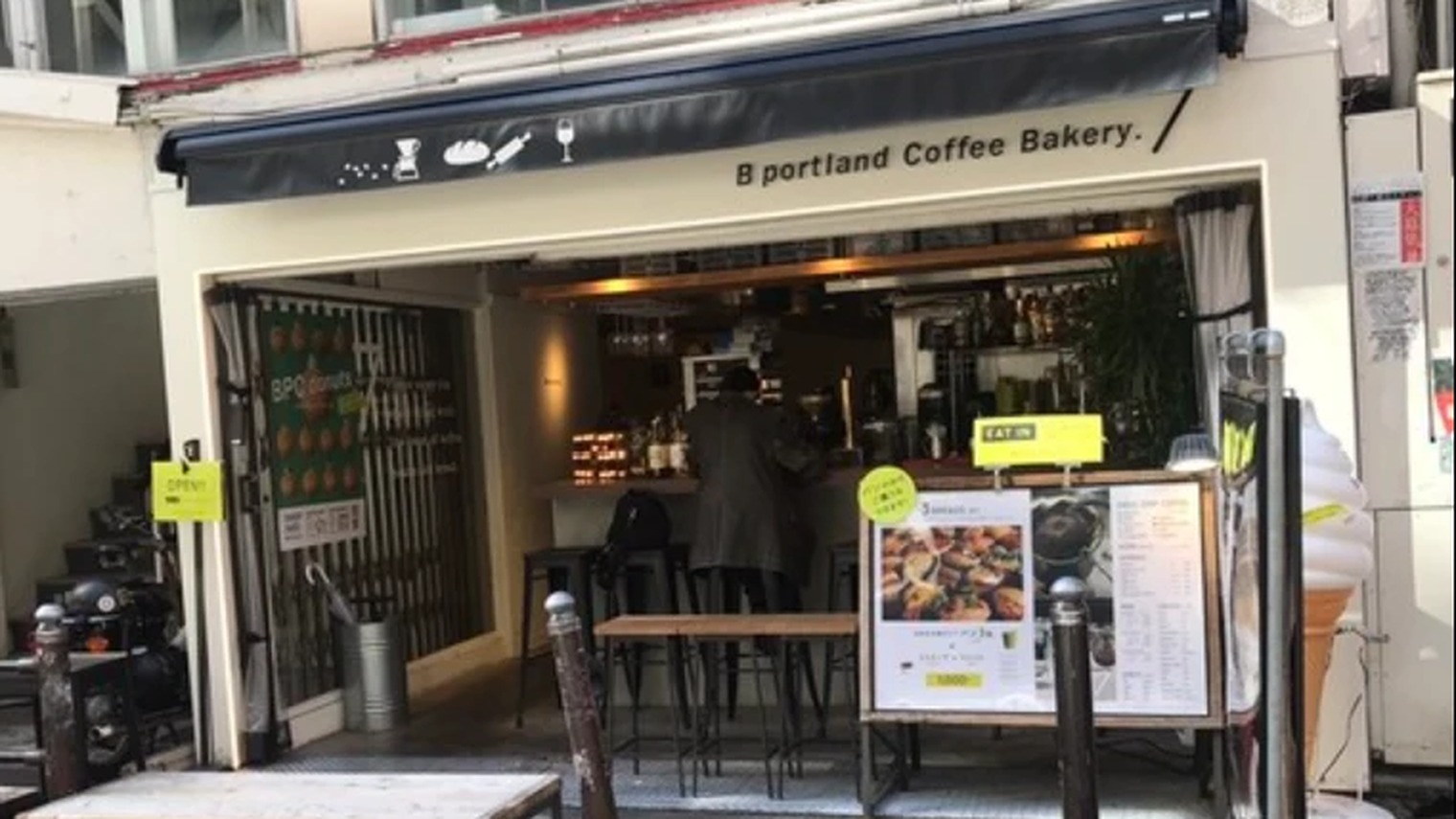 紺の日除けと全面開口が目印の B portland Coffee Bakery. の店頭（大阪・アメ村）
