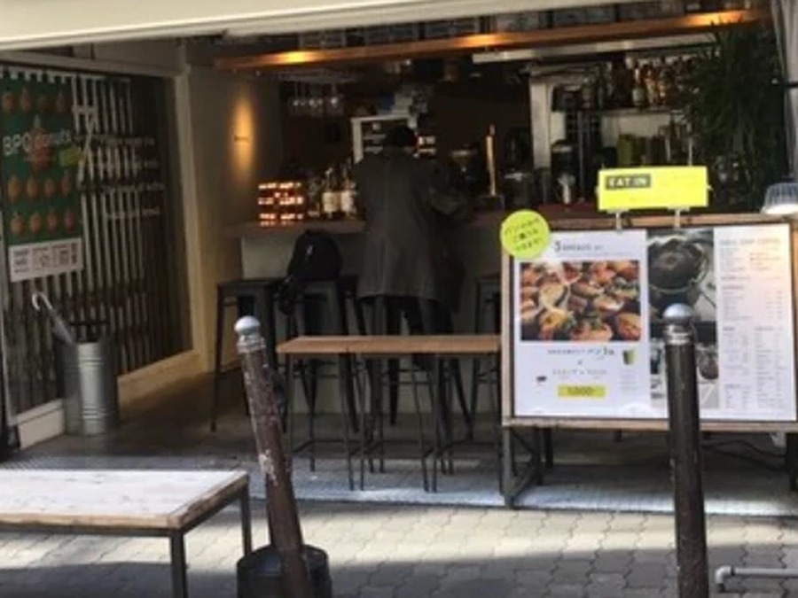 壁をまるごと開けた間口と、歩道のハイカウンター席
